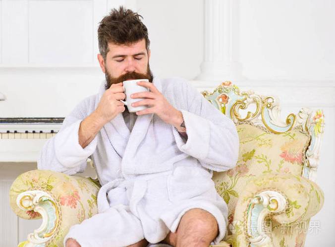 男子睡浴袍, 喝咖啡, 享受豪华酒店的香气, 在早晨, 白色背景.